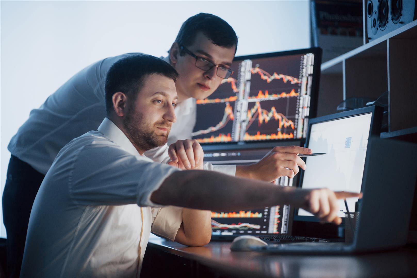 team-stockbrokers-are-having-conversation-dark-office-with-display-screens-analyzing-data-graphs-reports-investment-purposes-creative-teamwork-traders.jpg